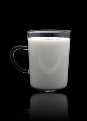 Glass mug of milk on a black background